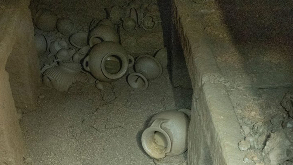 View inside dark tomb with various vessels
