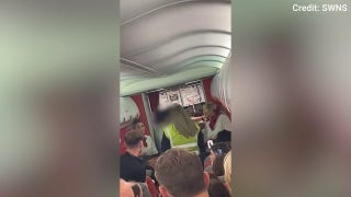 Officers escort two passengers off flight at UK airport