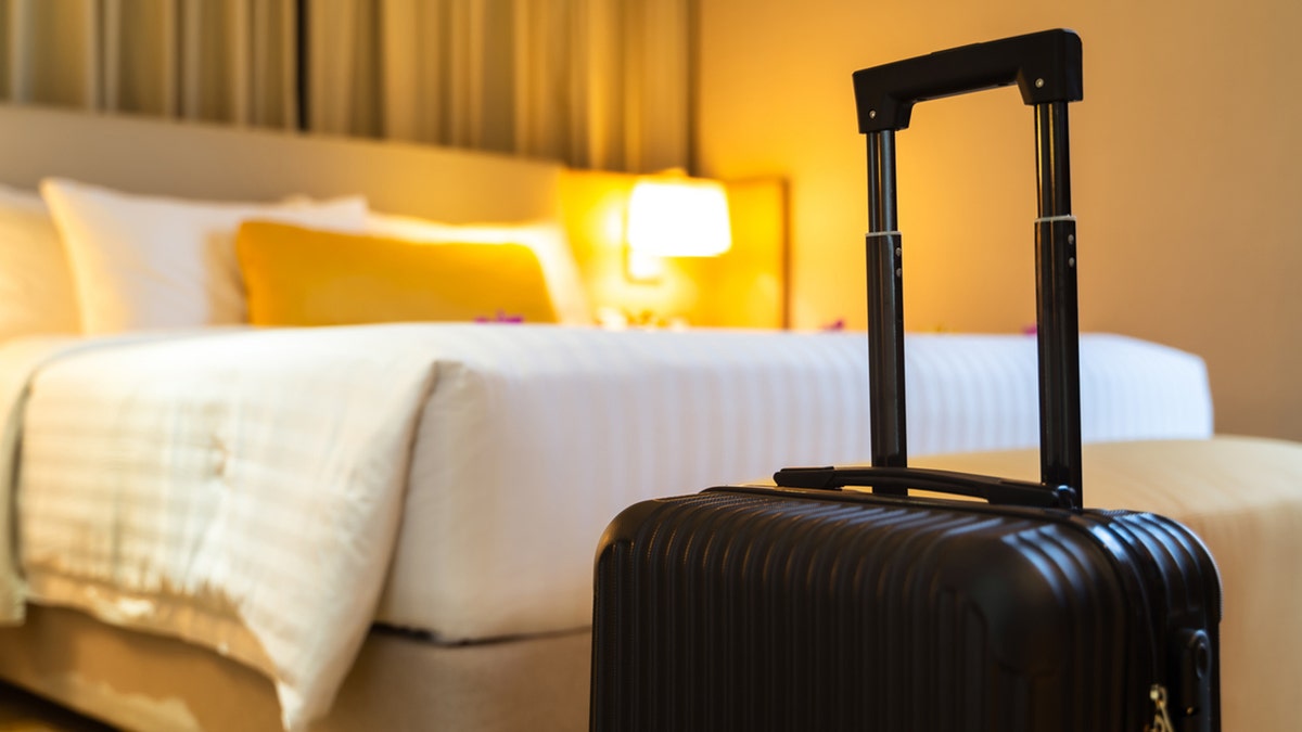 HOTEL ROOM with suitcase in foreground