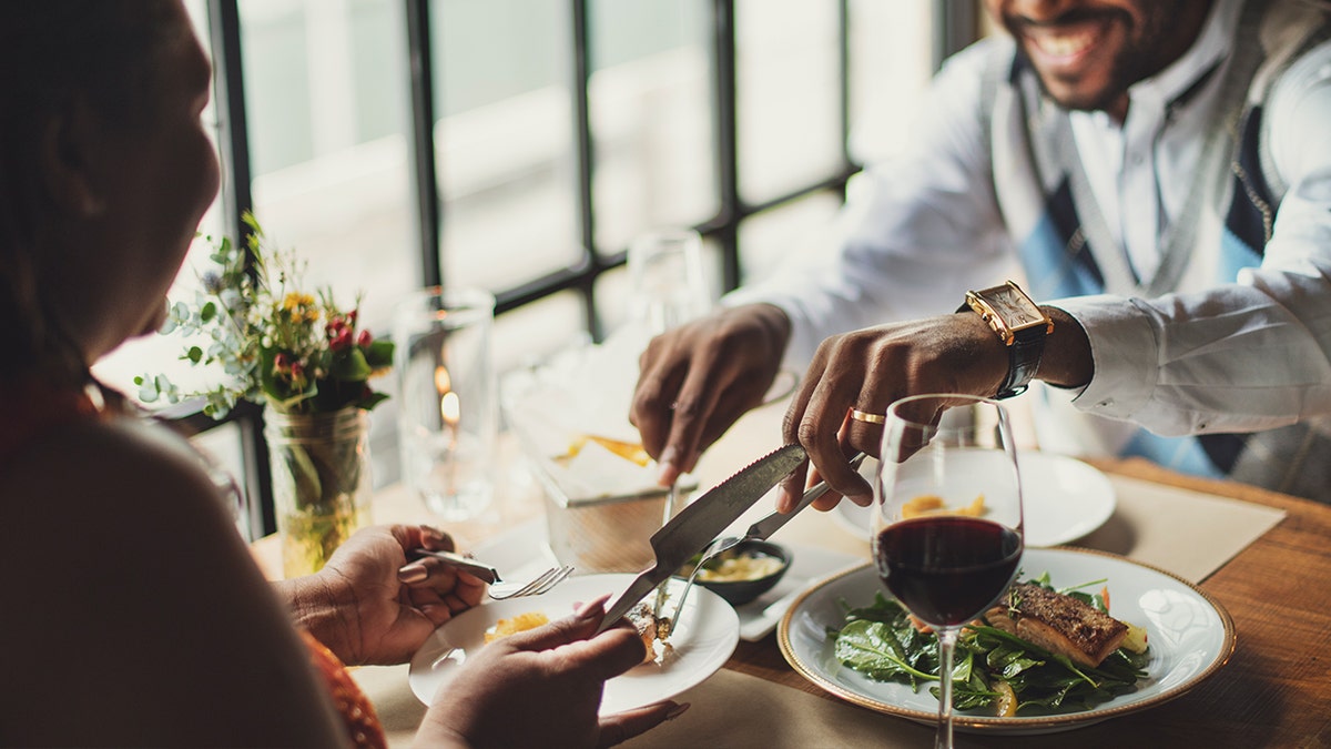 Diners enjoying steak with wine